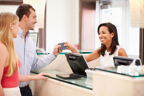 Recepcionista dejando entrar a los visitantes después de la verificación de credenciales